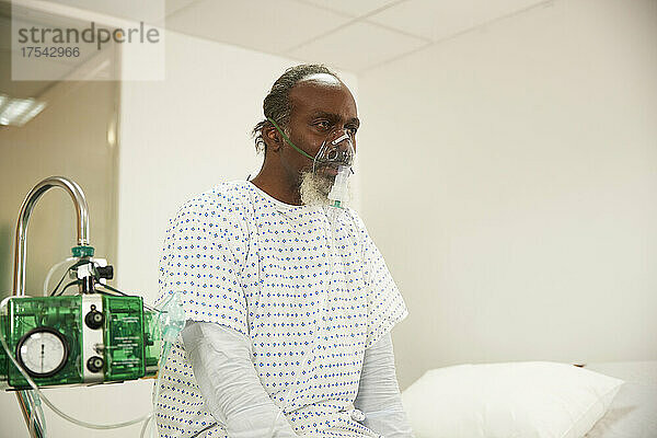 Ill patient wearing oxygen mask in medical room