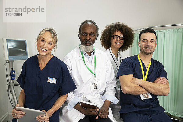 Lächelndes  selbstbewusstes  gemischtrassiges Gesundheitspersonal im Krankenzimmer