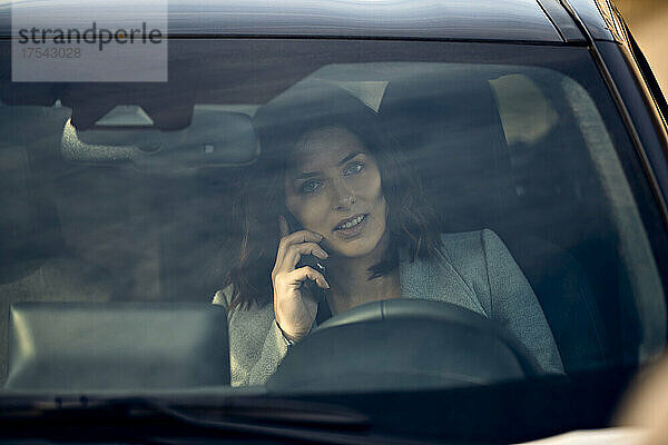 Frau telefoniert im Auto mit dem Handy