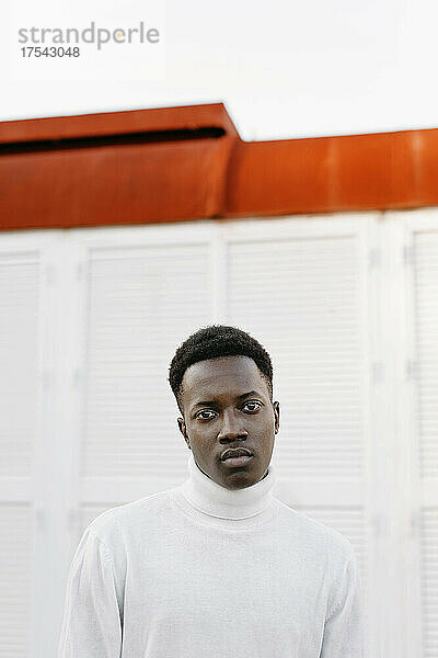 Confident young man wearing white turtleneck