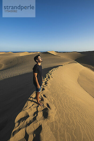 Tourist standing on sand dune at sunset  Grand Canary  Canary Islands  Spain