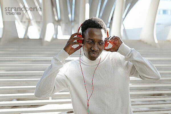 Young man listening music through headphones