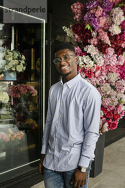Smiling man standing outside flower shop