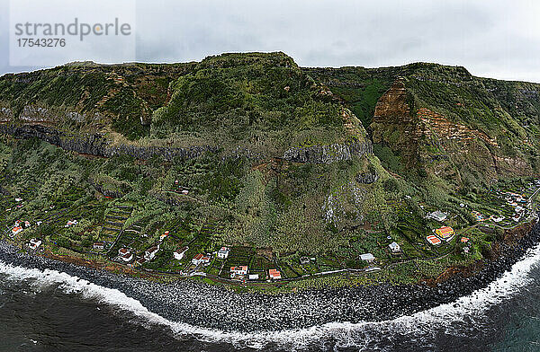 Houses on coast with mountain range at Rocha da Relva  Sao Miguel Island  Azores  Portugal