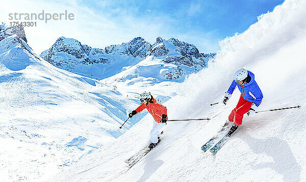 Mann und Frau beim Skifahren auf einem schneebedeckten Berg in Lech  Österreich