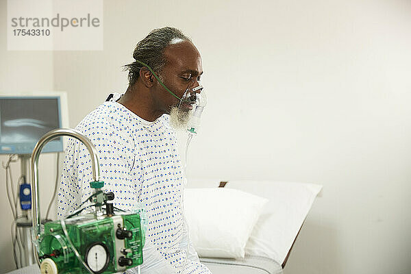 Patient wearing oxygen mask in medical room at hospital