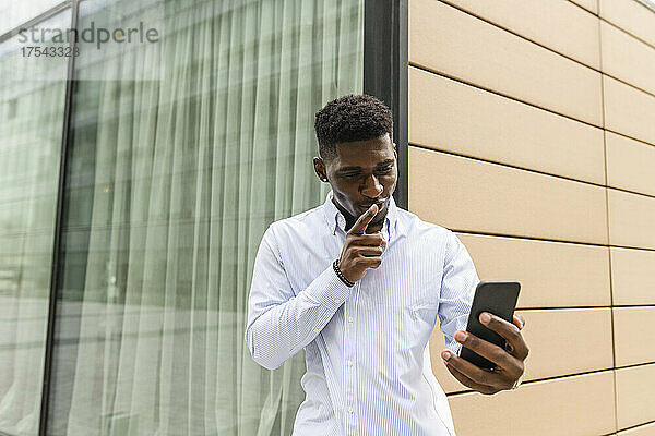 Young man with finger on lips during video call on smart phone