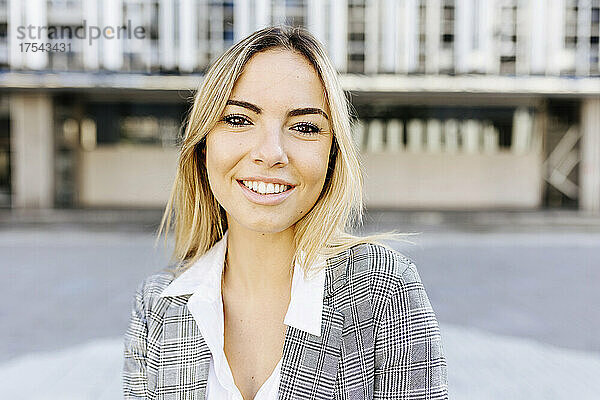 Lächelnde junge Geschäftsfrau mit blonden Haaren