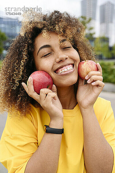 Lächelnde Frau mit geschlossenen Augen  die Äpfel hält