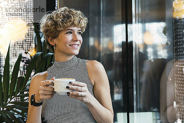 Thoughtful woman with coffee cup at cafe