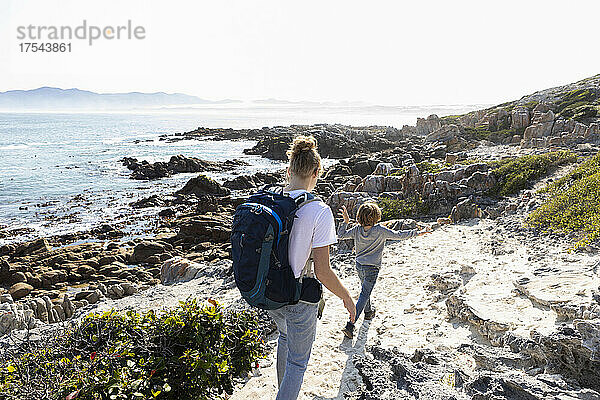Teenagermädchen und jüngerer Bruder wandern auf einem Küstenweg am Meer