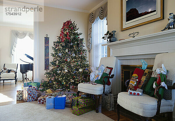 Wohnzimmer mit Weihnachtsbaum und Geschenken  traditioneller Dekoration  Kamin und Möbeln.