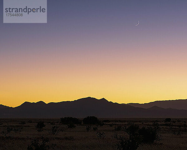 USA  New Mexico  Santa Fe  Halbmond über den Jemez Mountains bei Sonnenuntergang