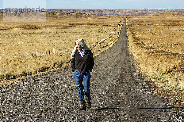 USA  Nevada  Winnemucca  Seniorin läuft eine Wüstenstraße entlang