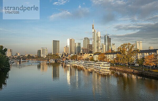 Ausflugsschiffe am Ufer  Blick über den Main  Skyline spiegelt sich im Fluss  Hochhäuser im Bankenviertel im Morgenlicht  Frankfurt am Main  Hessen  Deutschland  Europa