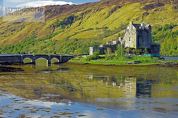 Burg spiegelt sich im Wasser  Brücke und Berge  Eilean Donan Castle  Highlands  Dornie  Schottland  Großbritannien  Europa