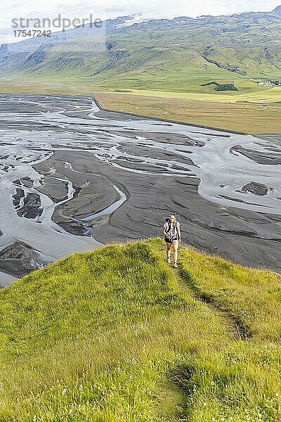 Wanderin auf einem Hügel  Blick über Schwemmland und Flusslandschaft  Fluss mäandert  Dímonarhellir  Suðurland  Island  Europa