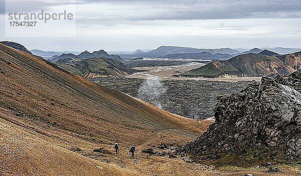 Zwei Wanderer auf dem Laugavegur  Landschaft bei Landmannalaugar  Dramatische Vulkanlandschaft  bunte Erosionslandschaft mit Bergen  Lavafeld  Landmannalaugar  Fjallabak Naturreservat  Suðurland  Island  Europa