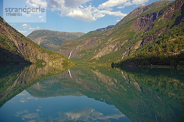 Berge und Wasserfall spiegeln sich im ruhigen Wasser eines Sees  Idyll  Skjolden  Westnorwegen  Norwegen  Europa