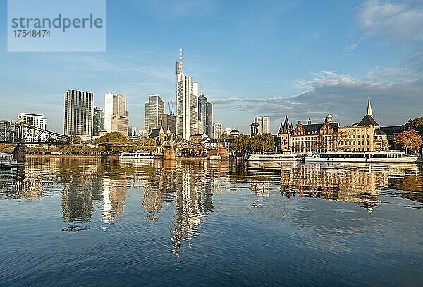 Ausflugsschiffe am Ufer  Blick über den Main  Skyline spiegelt sich im Fluss  Hochhäuser im Bankenviertel im Morgenlicht  Frankfurt am Main  Hessen  Deutschland  Europa