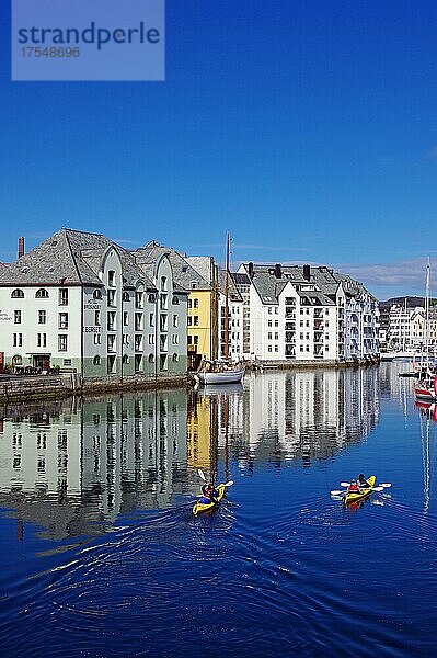 Kajakfahrer  Steinhäuser spiegeln sich in einem Hafenbecken  Jugendstil  Alesund  more og romsdal  Westnorwegen  Norwegen  Europa