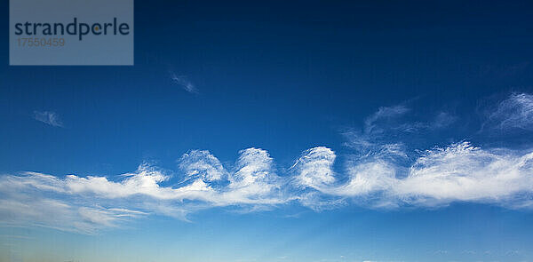 Stratocumulus floccus Wolkenbildung vor blauem Himmel