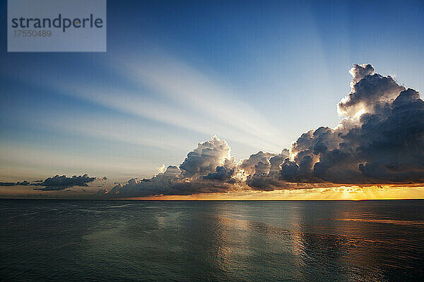 Wolken und Sonnenlicht über dem Meer bei Sonnenaufgang