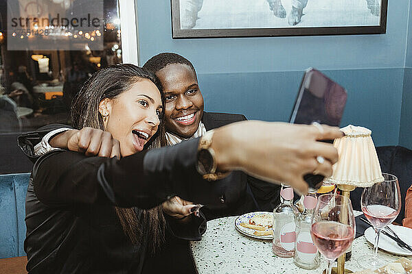 Junge männliche und weibliche Freunde nehmen Selfie durch Smartphone an der Bar