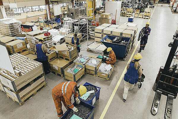 Männliche und weibliche Arbeiter in Uniform arbeiten in einem Fabriklager