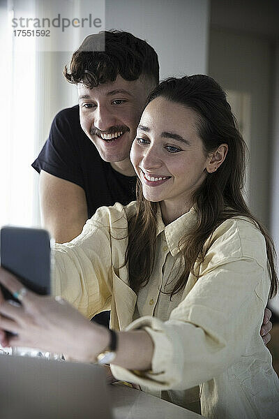 Glückliches Paar nimmt Selfie auf Smartphone zu Hause