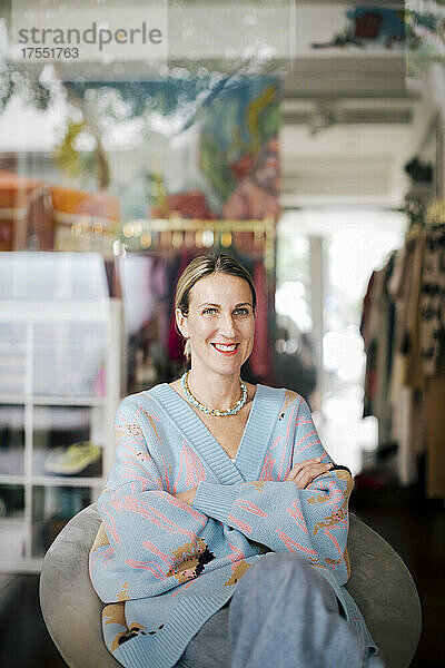 Porträt einer Unternehmerin  die in einem Bekleidungsgeschäft sitzt