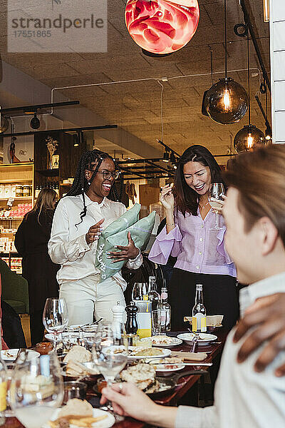 Multirassische Freundinnen lachen beim Feiern während einer Dinnerparty