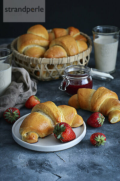 Croissants mit Erdbeermarmelade und frischen Erdbeeren