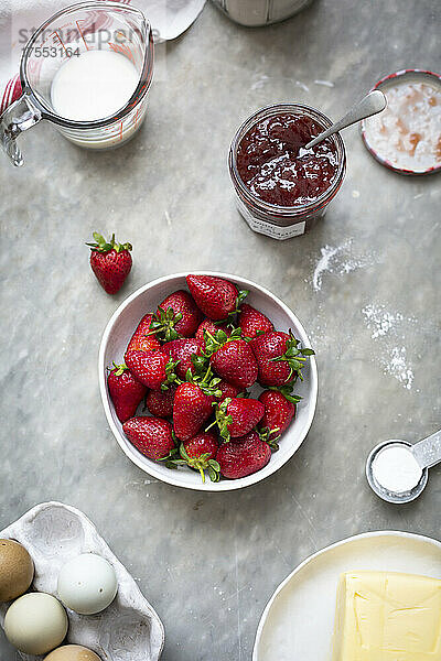 Schüssel mit Erdbeeren  Erdbeermarmelade  Milch  Butter und Eier