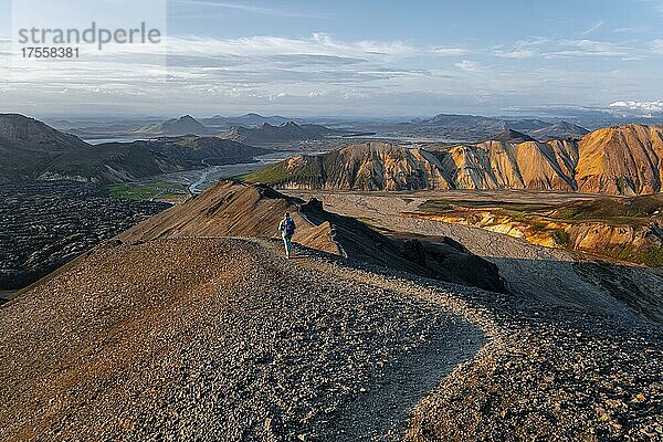 Wanderin auf dem Trekkingweg Laugavegur  Trekkingweg Laugavegur  Dramatische Vulkanlandschaft  bunte Erosionslandschaft mit Bergen  Lavafeld  Landmannalaugar  Fjallabak Naturreservat  Suðurland  Island  Europa