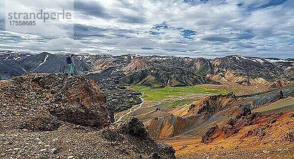 Wanderin auf dem Trekkingweg Laugavegur  Trekkingweg Laugavegur  Dramatische Vulkanlandschaft  bunte Erosionslandschaft mit Bergen  Lavafeld  Landmannalaugar  Fjallabak Naturreservat  Suðurland  Island  Europa