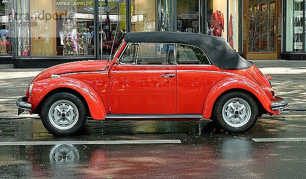 Ein roter VW Käfer Cabrio steht auf dem regennassen Kurfürstendamm in Berlin  Deutschland  Europa