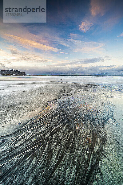 Sonnenuntergang über dem schwarzen Sand des Skagsanden-Strandes  der im Winter mit Eis bedeckt ist  Flakstad  Provinz Nordland  Lofoten  Norwegen  Skandinavien  Europa