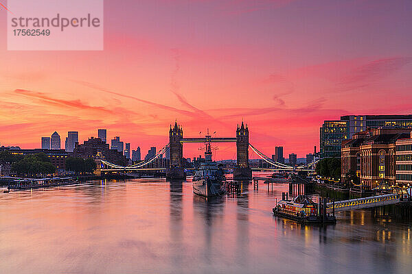 Tower Bridge  Themse und HMS Belfast bei Sonnenaufgang mit rosa Himmel  und Canary Wharf im Hintergrund  London  England  Vereinigtes Königreich  Europa