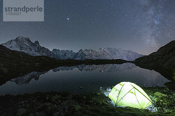Beleuchtetes Zelt unter den Sternen am Lacs des Cheserys mit dem Mont-Blanc-Massiv  das sich im Wasser spiegelt  Chamonix  Haute Savoie  Französische Alpen  Frankreich  Europa
