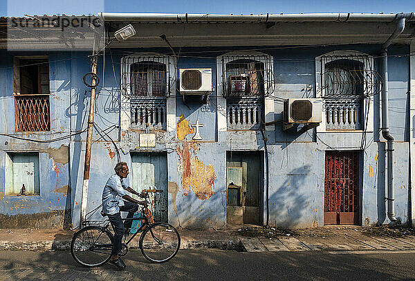 Einheimischer Mann auf einem Fahrrad in den Seitenstraßen  Panjim City  Panjim (Panaji)  Goa  Indien  Asien