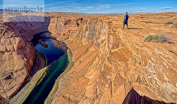 Ein Mann wandert am Rande einer Klippe mit Blick auf Horseshoe Bend in der Nähe von Page  Arizona  Vereinigte Staaten von Amerika  Nordamerika