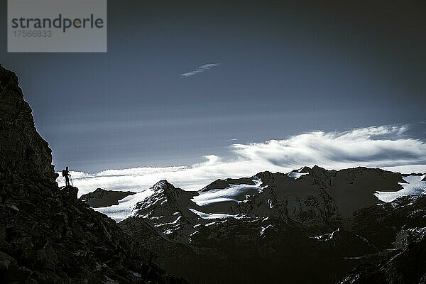 Bergsteiger auf Felsvorsprung mit Südtiroler Bergen bei blauer Stunde  Martelltal  Naturns  Südtirol  Italien  Europa