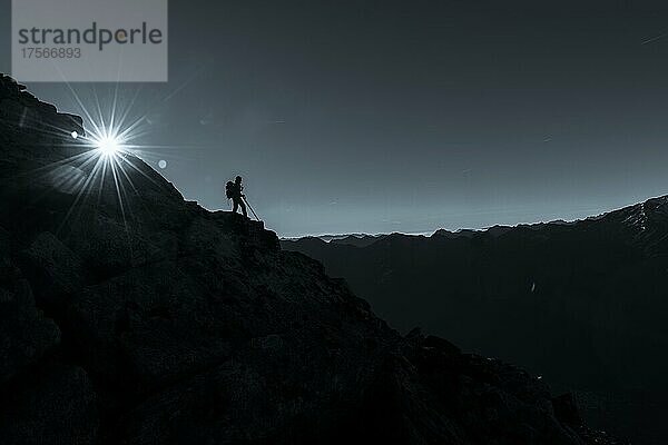 Bergsteiger auf Felskante mit Sonnenstern  im Hintergrund Südtiroler Berge  Naturns  Südtirol  Italien  Europa