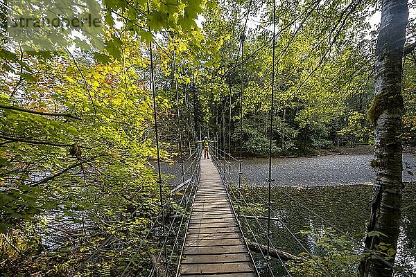 Wanderer auf Hängebrücke in herbstlichem Wald  Grove of the Patriarchs Trail  Mount Rainier National Park  Washington  USA  Nordamerika
