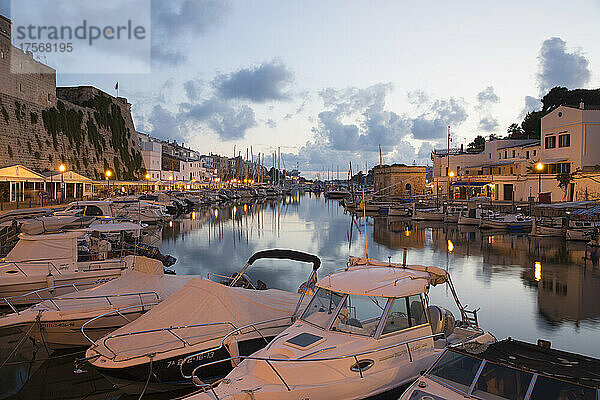 Blick vom Kai über den Hafen in der Abenddämmerung  Lichter spiegeln sich im ruhigen Wasser  Ciutadella (Ciudadela)  Menorca  Balearische Inseln  Spanien  Mittelmeer  Europa