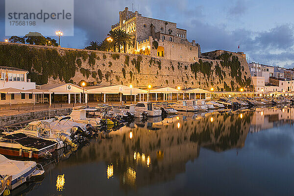 Blick über den ruhigen Hafen auf das beleuchtete Rathaus in der Abenddämmerung  Ciutadella (Ciudadela)  Menorca  Balearische Inseln  Spanien  Mittelmeer  Europa