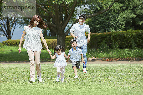 Japanische Familie macht einen Spaziergang im Park