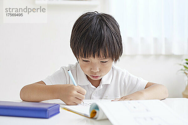 Japanischer Grundschuljunge macht seine Hausaufgaben