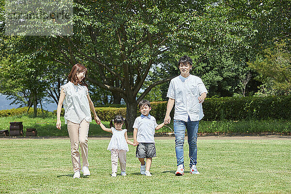 Japanische Familie spaziert im Park